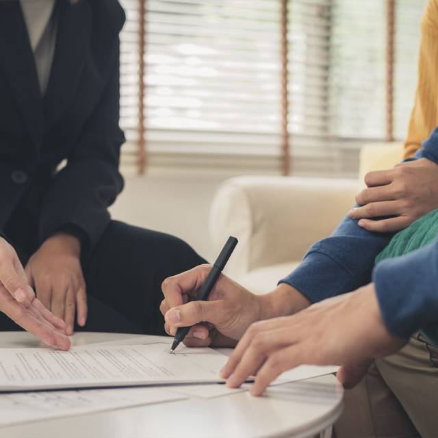 corredor de seguros firmando con pareja